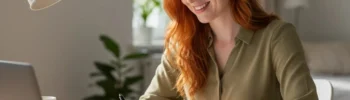 Junge Frau arbeitet konzentriert am Schreibtisch, prüft ihre Finanzen und optimiert ihre Kreditwürdigkeit.